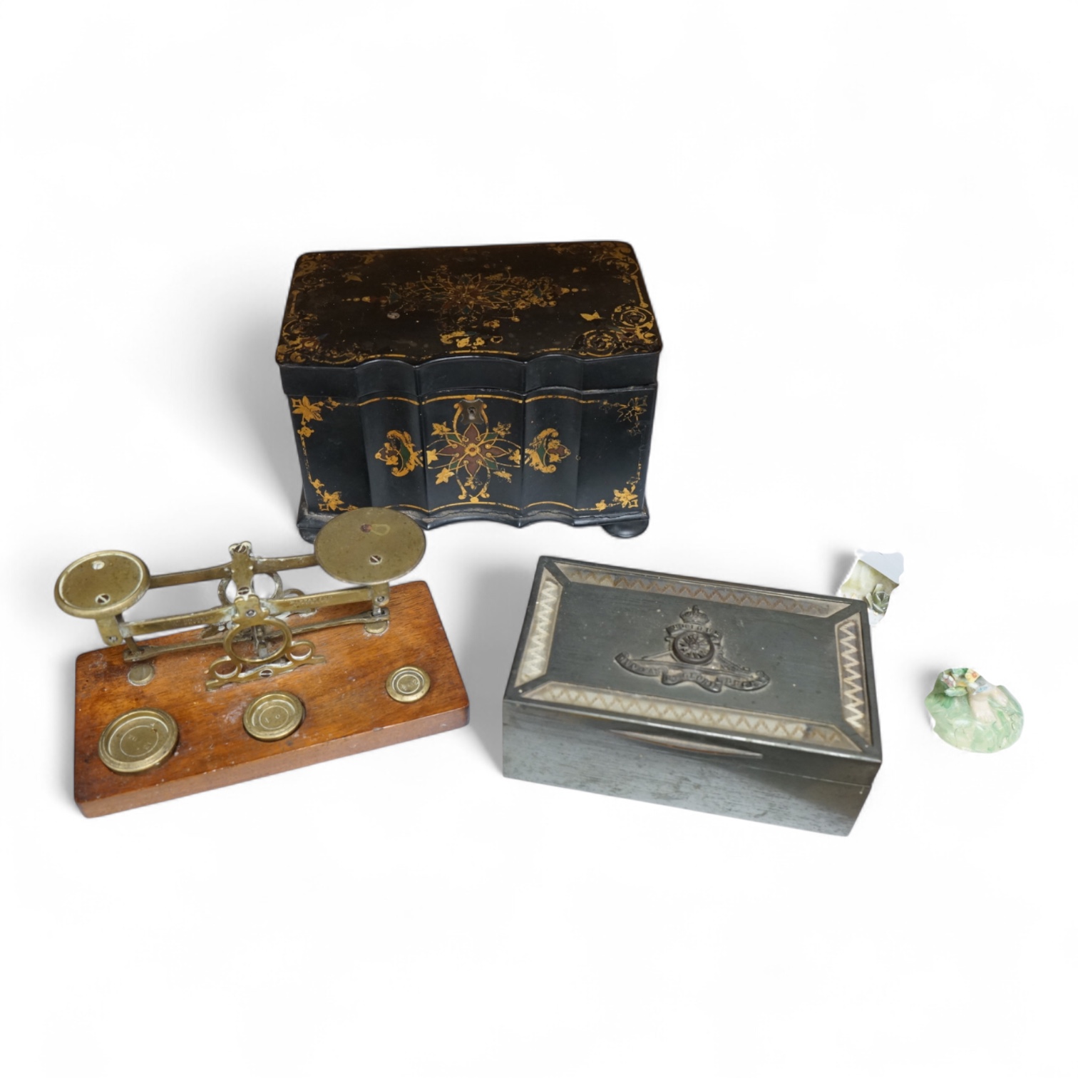A Victorian papier maché tea caddy, postal scales and a military interest cigarette box, largest 19cm wide